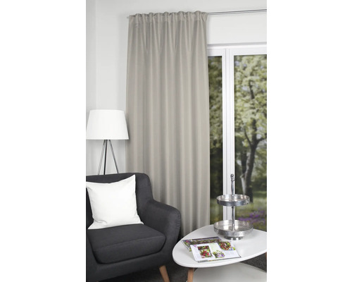 Dekorative Gardine neben Sessel und Tisch in einem Wohnzimmer