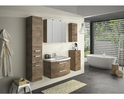 Badezimmer mit Waschtisch, Spiegelschrank, Hochschrank und Badewanne in einem hellen Raum