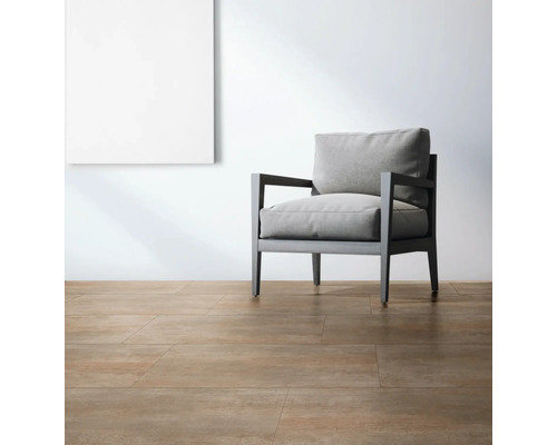 Heller Raum mit Bodenfliesen, Sessel und einem Bild an der Wand