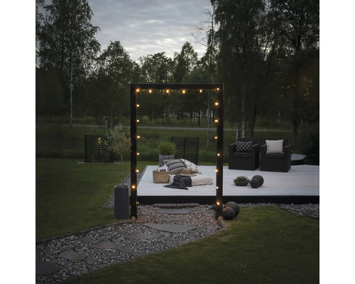 Garten mit Holzterrasse, Sitzgelegenheiten und Lichterkette für eine gemütliche Atmosphäre