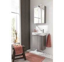 Badezimmer mit Waschtisch, Spiegelschrank, Handtüchern und Dekoration
