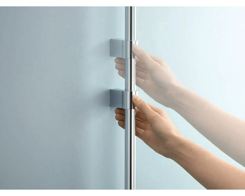 Person bedient eine Duschstange mit Halterung an einer Wand.