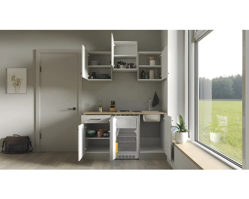 Kompakte Küchenzeile mit Spüle, Kochfeld und Kühlschrank in einem hellen Raum