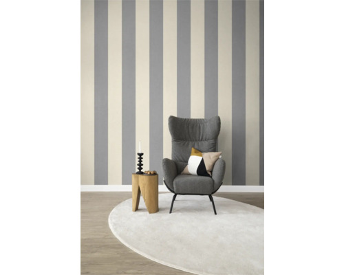 Wohnzimmer mit gestreifter Tapete, Sessel, Teppich und Beistelltisch