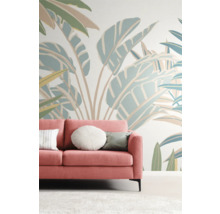 Wohnzimmer mit pinkfarbenem Sofa vor einer Wand mit Pflanzenmuster