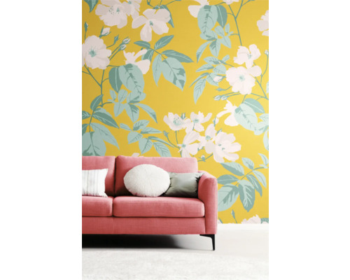 Zimmer mit rosafarbenem Sofa vor einer Wand mit floralem Muster