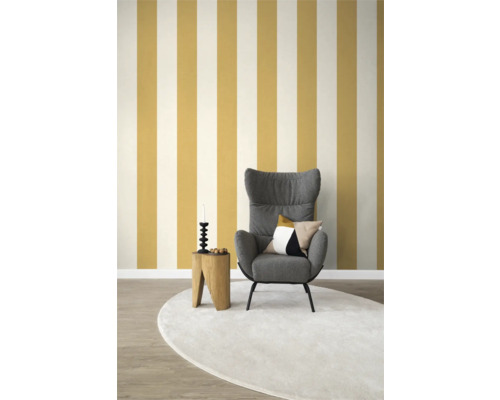 Wohnzimmer mit Sessel, Beistelltisch, Dekorationsgegenständen und gestreifter Tapete