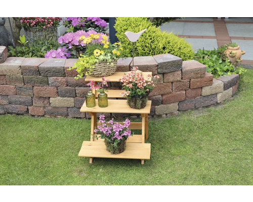 Mehrstöckiges Pflanzenregal aus Holz mit verschiedenen Topfpflanzen im Garten