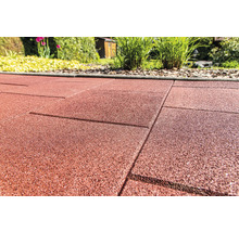 Nahaufnahme von roten Terrassenplatten aus Gummi im Garten.