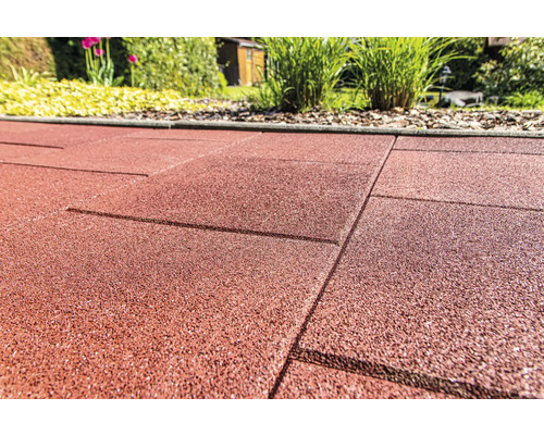 Nahaufnahme von roten Terrassenplatten aus Gummi im Garten.