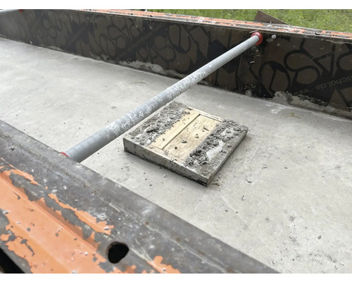 Betonplatte in Form mit Stützstange und Holzblock