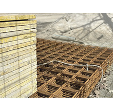 Stapel Holzschalungselemente neben Bewehrungsmatten