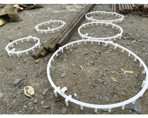 Mehrere Abstandshalter aus Kunststoff für Bewehrungskörbe auf einer Baustelle