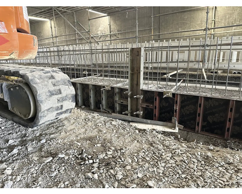 Baustelle mit Schalung, Armierung und Raupenbagger