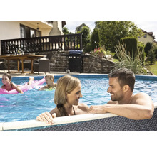 Familie entspannt im Gartenpool mit Grillplatz