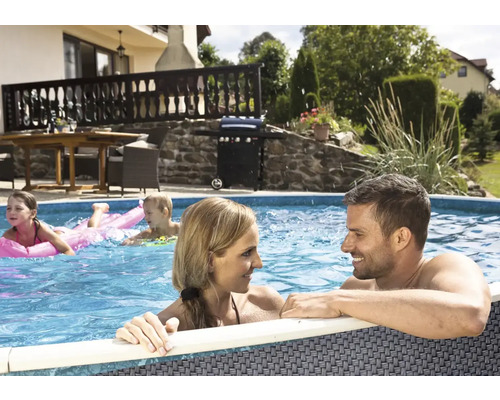 Familie entspannt im Gartenpool mit Grillplatz