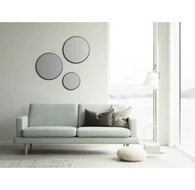 Helles Wohnzimmer mit Sofa, runden Spiegeln und Stehlampe