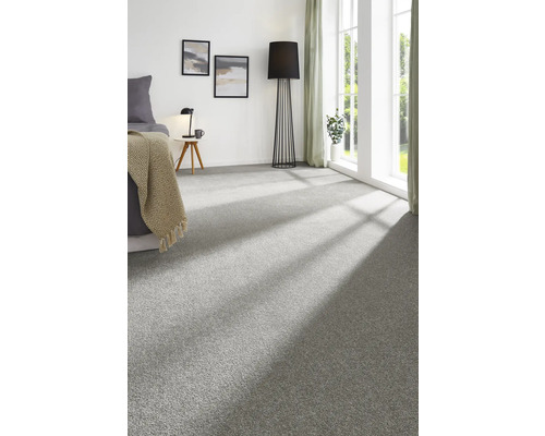 Grauer Teppichboden in einem Schlafzimmer mit Bett, Stehlampe und Fenster.