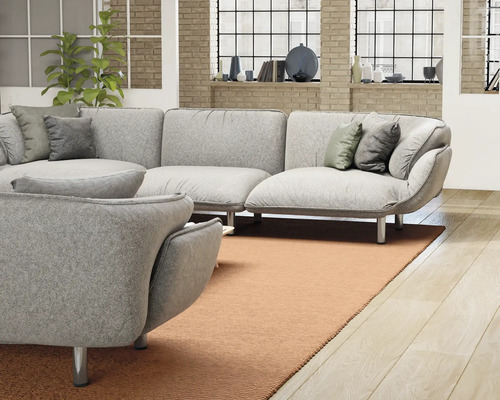 Helles Wohnzimmer mit grauer Eckcouch, Zierkissen und Teppich