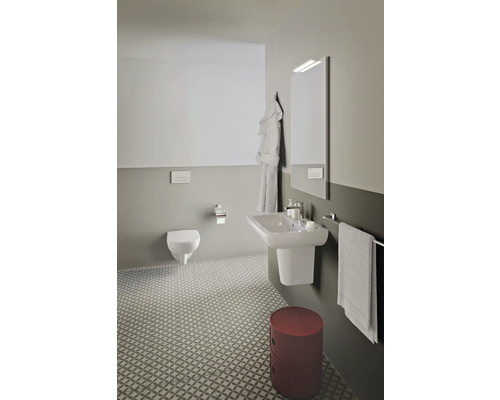 Helles Badezimmer mit Wand-WC, Waschbecken, Spiegel, Handtuchhalter und gemustertem Fliesenboden