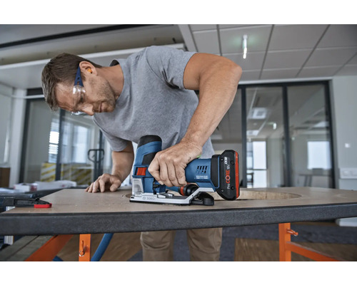 Mann arbeitet mit einer Akku-Stichsäge an einer Holzplatte