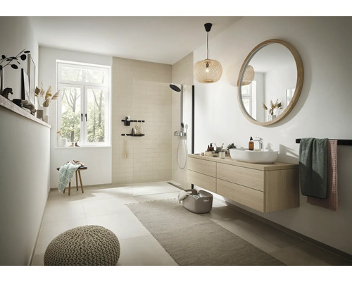 Helles Badezimmer mit Dusche, Waschtisch, Spiegel und Dekorationen für ein modernes Ambiente.