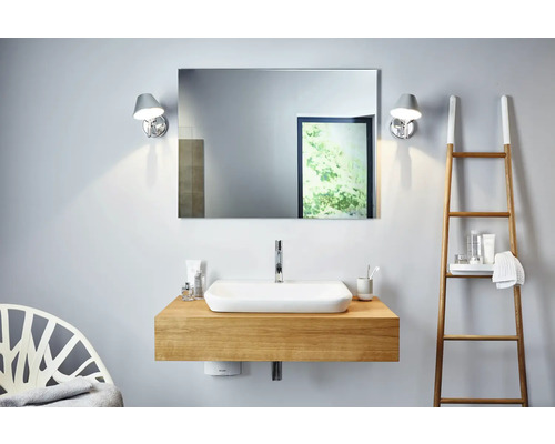 Modernes Badezimmer mit Waschtisch, Spiegel, Lampen und Leiterregal.