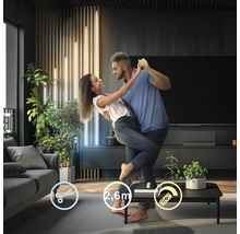 Tanzendes Paar im Wohnzimmer mit dekorativer Beleuchtung und modernem Interieur