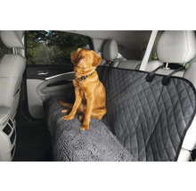 Hund sitzt auf einem Autositzbezug mit Diamantmuster und Teppichstruktur