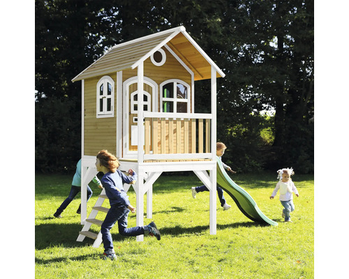 Spielhaus aus Holz mit Rutsche und spielenden Kindern im Garten