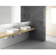 Badezimmer mit zwei Waschbecken, Spiegel und Steinwand