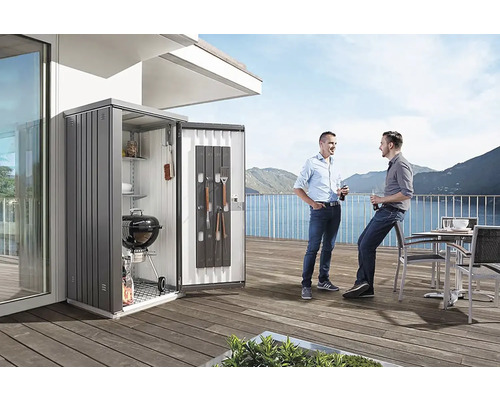 Szene mit einem Geräteschrank auf einer Terrasse, in dem ein Grill und Zubehör aufbewahrt werden, und zwei Personen