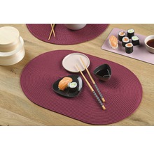 Gedeckter Tisch mit Platzsets, Geschirr und Sushi
