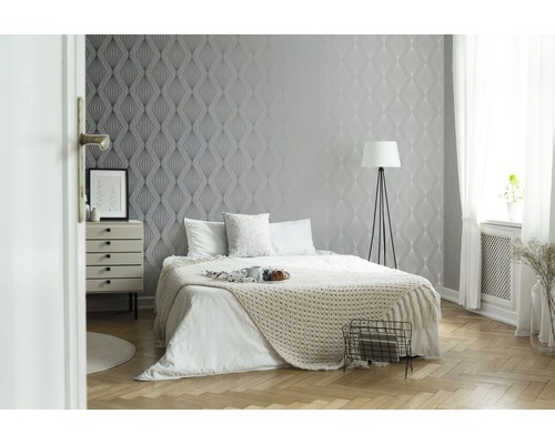 Schlafzimmer mit gemusterten Tapeten, Bett und Nachttisch