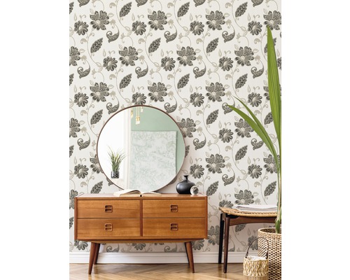 Dekoratives Zimmer mit gemusterter Tapete, Kommode, Spiegel und Pflanze