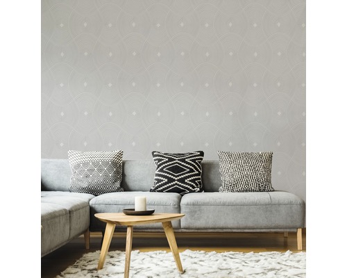 Wohnzimmer mit grauer Couch, Kissen und Tapete mit geometrischem Muster