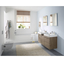 Helles Badezimmer mit Badewanne, Toilette, Waschbecken und Spiegel