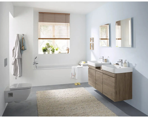 Helles Badezimmer mit Badewanne, Toilette, Waschbecken und Spiegel