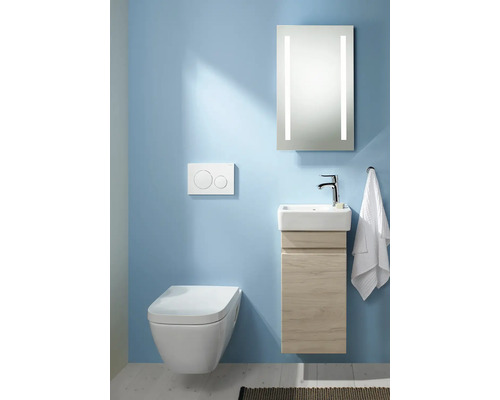 Modernes Badezimmer mit Wandtoilette, Waschbeckenunterschrank und beleuchtetem Spiegel