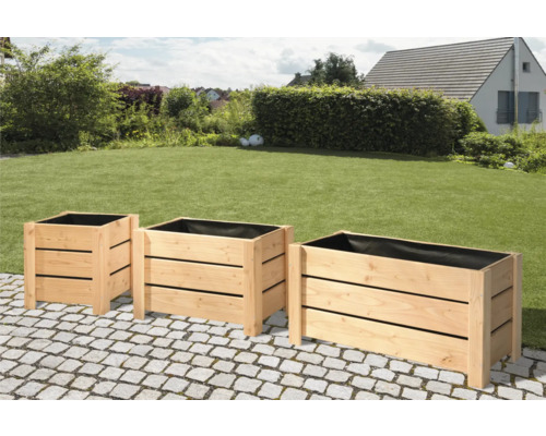 Drei Pflanzkästen aus Holz im Garten.