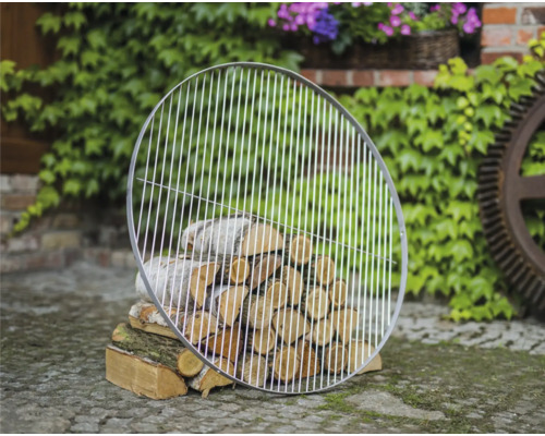 Runder Grillrost aus Metall über einem Holzstapel