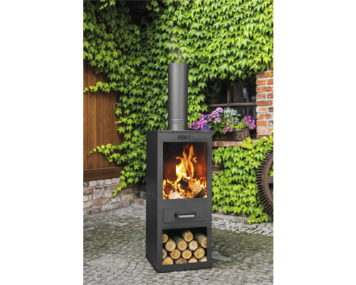 Außenkamin mit Holz im Feuerraum und Holzlagerung im Garten