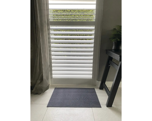 Bodenmatte mit Kreisdesign vor einem Fenster mit Jalousien