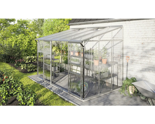 Gewächshaus mit Regalen, Pflanzen und Gartengeräten in einem Garten