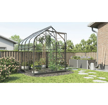Gewächshaus im Garten mit Hochbeet und Gartenwerkzeugen
