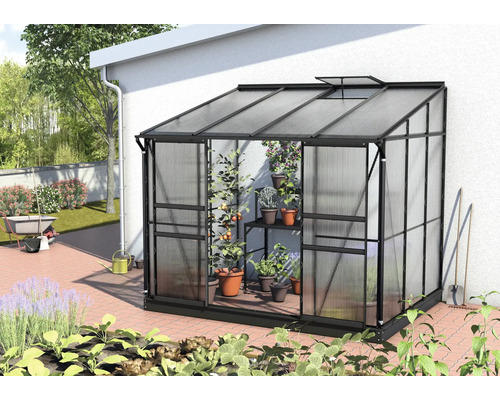 Gewächshaus aus Metall und Kunststoff mit Pflanzen im Garten