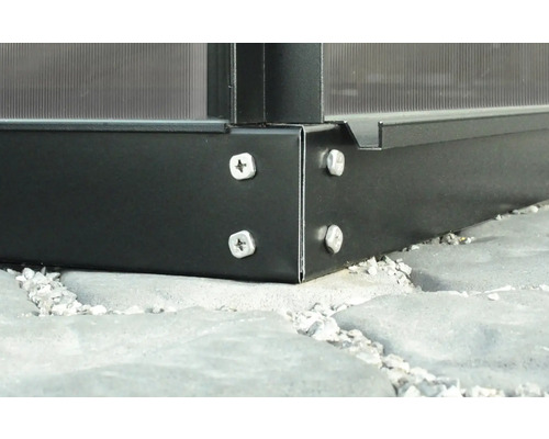 Detailansicht einer Gewächshaus-Ecke mit Schrauben auf Steinfliesen