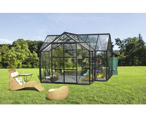 Gewächshaus mit Pflanzen, Möbeln und Wassertank im Garten