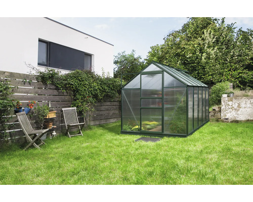 Gewächshaus im Garten mit Rasenfläche und Holzzaun
