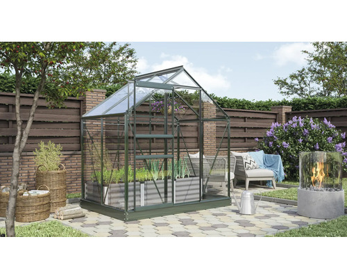 Gewächshaus im Garten mit Pflanzen und Gartendekoration